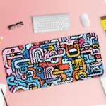 Colorful abstract maze design desk pad with wavy lines in blue, pink, yellow, white, and black on a light blue background. Desk Pad with Keyboard and Mouse