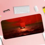 Infidu desk pad featuring a small boat on a red ocean under a red sky, capturing a serene sunrise or sunset scene. Desk Pad with Keyboard and Mouse