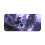 Desk pad with a silhouette of a motocross rider mid-jump against a foggy cityscape in blue and purple tones. Desk Pad kept on a plain white background