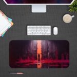 The silhouetted figure standing before a glowing orange portal, surrounded by deep purples and reds on the Infidu Artistic Desk Pad. Design Kept on a computer table