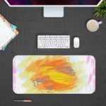 Infidu Artistic Desk Pad with colorful splashes of orange, pink, and purple on a white background. Design Kept on a computer table