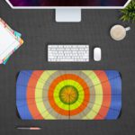 Infidu Artistic Desk Mat with circular pattern and concentric rings in orange, yellow, blue, and green. Design Kept on a computer table