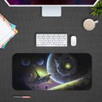 Infidu Space Desk Mat featuring multiple planets and a spacecraft against a deep space background with stars, in shades of blue and green. Desk Pad with Keyboard and Mouse in gray background