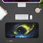 Infidu Space Desk Mat features a large glowing planet or star against a dark space background with swirling yellow-green gases. Desk Pad kept on a gray background