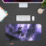 Desk pad with a silhouette of a motocross rider mid-jump against a foggy cityscape in blue and purple tones. Design Kept on a computer table