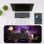 Futuristic gaming-themed desk pad with a VR headset gamer, vibrant outer space background, and dynamic purple, blue, and yellow colors. Desk Mat with an Apple Laptop