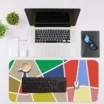 Infidu Artistic Desk Pad with horizontal stripes in pink, yellow, purple, blue, and red. Desk Mat with an Apple Laptop