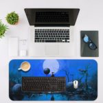 Anime-inspired Infidu Artistic Desk Pad with a blue, foggy scene, barren trees, stones, a full moon, and a mysterious figure on a reflective surface. Desk Mat with an Apple Laptop