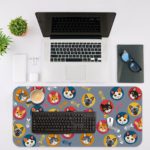 Desk pad with colorful cat faces in circles and playful fish designs on a blue background. Desk Mat with an Apple Computer