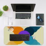 Infidu Artistic Desk Mat with a circular pattern in overlapping shades of yellow, orange, purple, and blue. Desk Mat with an Apple Laptop