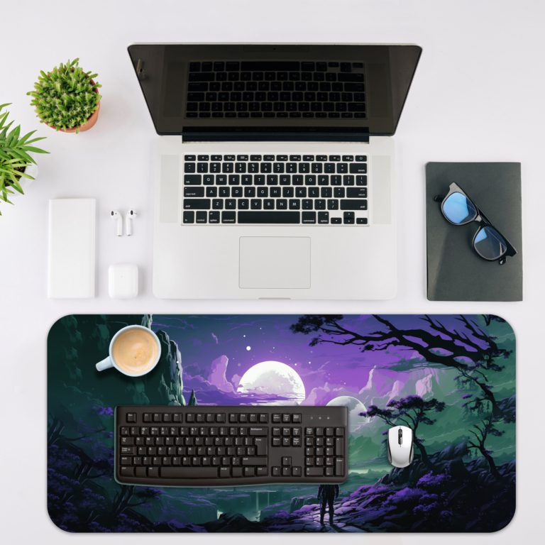 Infidu Space Desk Pad features a silhouette of a person looking at a surreal mountain view under a bright moon with floating celestial bodies. Desk Mat with a laptop