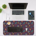 Infidu Creative Gaming Joystick Pattern Desk Pad featuring a dark maroon background with colorful illustrations of game controllers, headphones, and cassette tapes Game Design Kept on a laptop table