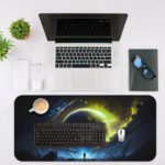 Infidu Space Desk Mat features a large glowing planet or star against a dark space background with swirling yellow-green gases. Desk Pad on the computer table