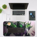 Desk pad featuring a futuristic armored figure or mecha with glowing green elements against a misty, atmospheric background. Desk Mat with an Apple Laptop