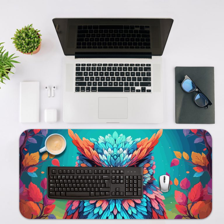 Illustration of a colorful owl with vibrant blue, purple, and orange feathers on a teal and turquoise background on the Infidu Artistic Animated Desk Mat with a laptop