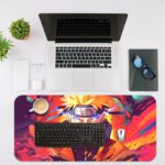 Naruto anime character with spiky blonde hair and headband against a colorful, explosive background in shades of purple, pink, orange, and blue. Desk Mat with an Apple Laptop