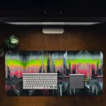 Abstract glitch art of a stylized cityscape with tall buildings silhouetted against a colorful, dreamy sky. Desk Pad in computer table