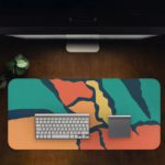 Infidu Artistic Desk Pad with angular shapes in green, orange, and blue on a dark background. Desk Pad in computer table