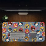 Desk pad with colorful cat faces in circles and playful fish designs on a blue background. Desk Pad on the computer table