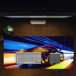 Desk pad featuring a stylized sports car in motion with blue, yellow, and orange light trails. Desk Pad in computer table