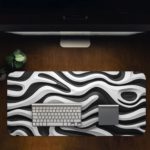 Infidu Artistic Pattern Desk Pad with a black background and parallel white wave lines. Design Kept on a computer table