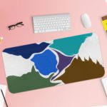 Infidu Artistic Desk Mat with an abstract landscape design in blue, white, green, and brown. Desk Pad with Keyboard and Mouse