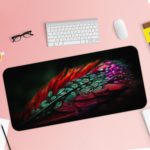 Colorful feather or leaf design with red, blue, green, and purple gradient pattern. Desk Pad with Keyboard and Mouse