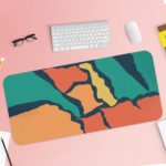 Infidu Artistic Desk Pad with angular shapes in green, orange, and blue on a dark background. Desk Pad with Keyboard and Mouse