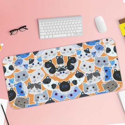 Desk pad with colorful blue, grey, and black cat faces on a sandal-colored background. Desk Pad with Keyboard and Mouse