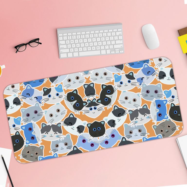 Desk pad with colorful blue, grey, and black cat faces on a sandal-colored background. Desk Pad with Keyboard and Mouse