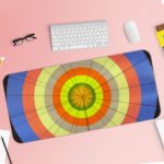 Infidu Artistic Desk Mat with circular pattern and concentric rings in orange, yellow, blue, and green. Desk Pad with Keyboard and Mouse