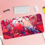 Illustration of two colorful parrots on a branch surrounded by pink and red flowers on the Infidu Artistic Animated Desk Pad with Keyboard and Mouse