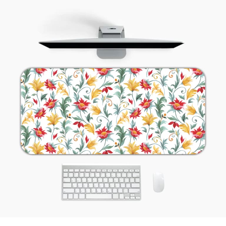 White desk mat with a large floral pattern featuring red, yellow, and blue flowers, and green leaves, adding a vibrant touch to your desk. Desk Mat with a computer