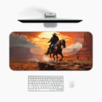 Desk pad with a horse rider against a vivid orange sunset and reddish-brown desert landscape, with dark cliffs and horse in contrasting colors. A desk pad under the computer