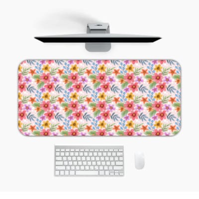 Light pink desk mat with a vibrant floral pattern featuring pink, red, and yellow flowers and blue leaves for a creative workspace touch. Desk Pad on the computer table