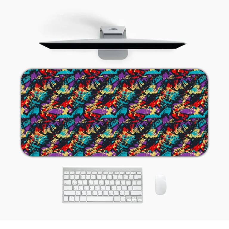 Infidu Vector Pattern Desk Pad with an abstract, chaotic pattern in reds, blues, greens, and yellows against a dark background. Desk Mat with a laptop