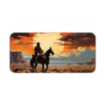 Silhouette of a rider on a horse with a sunset background, featuring dramatic orange and red clouds against a desert-like landscape. Desk Pad kept on a plain white background