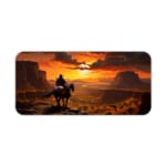 Horse rider in scenic desert sunset with large rock formations and warm sunset colors on a desk pad. Desk Pad kept on a plain white background