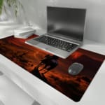 Desert sunset desk pad with a silhouette of a horse rider against a deep orange and red sky, creating a dramatic western scene. the desk pad is kept on the laptop