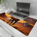 Running horse at sunset desk pad with a light brown horse in a desert landscape, dramatic sunset sky, and flowing mane. the desk pad is kept on the laptop