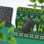 Infidu Knitted Pattern Desk Pad with a dark green background featuring white reindeer, Christmas trees, and snowflakes. Desk Pad with Keyboard and Mouse