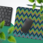 Infidu Desk Pad with a blue background featuring a zigzag knitted pattern in shades of blue, green, and yellow. Desk Pad with Keyboard and Mouse