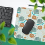 INFIDU desk mat featuring a playful lion and giraffe design on a light green background, perfect for kids’ studying, drawing, or gaming Desk Pad on the mouse