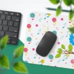 Infidu Lovely Singing Parrot Desk Pad with a white background and musical design, featuring a vibrant comic-style illustration. Desk Pad with Keyboard and Mouse