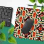 Infidu desk pad with an ornate floral pattern in orange, red, and cream on a light cream background, adding elegance to your workspace. Desk Pad with Keyboard and Mouse