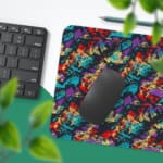 Infidu Vector Pattern Desk Pad with an abstract, chaotic pattern in reds, blues, greens, and yellows against a dark background. Desk Pad with Keyboard and Mouse