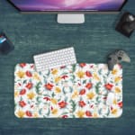 White desk mat with a large floral pattern featuring red, yellow, and blue flowers, and green leaves, adding a vibrant touch to your desk. Desk Pad with Keyboard and Mouse in green background