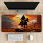 Desk pad with a horse rider against a vivid orange sunset and reddish-brown desert landscape, with dark cliffs and horse in contrasting colors. desk pad kept on the table