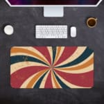 Infidu Flashback Design Desk Pad with a sunburst pattern in red, orange, brown, and blue for a retro, vintage look. Desk Pad with Keyboard and Mouse in gray background