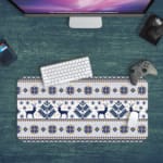 Infidu Desk Pad with white background, featuring blue and yellow reindeer, snowflakes, and geometric shapes in a knitted pattern. Desk Pad kept on a gray background